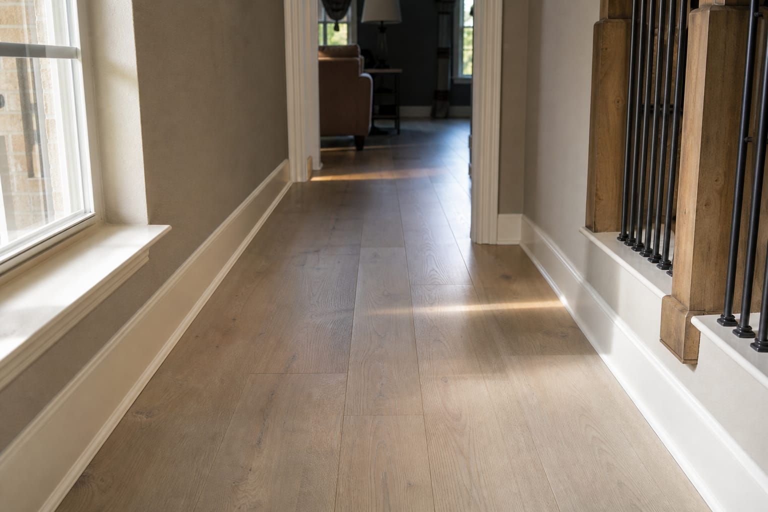 Parquet flottant clair dans un couloir de maison, lumière naturelle traversant une fenêtre latérale